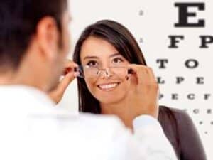 Image of an optometrist helping a patient try on a pair of glasses.