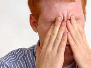 Image of a man rubbing his eyes.