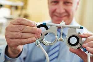 Image of an optometrist holding an eye examination tool.