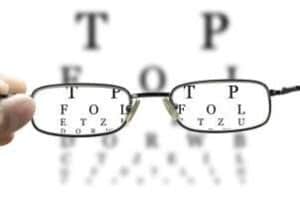 hand holding glasses to eye chart