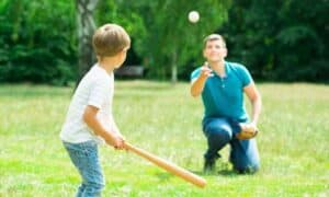 boy playing baseball with father