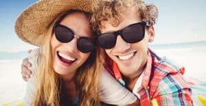 Image of man and woman wearing sunglasses. 