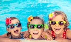 Happy kids in a pool wearing funky sunglasses