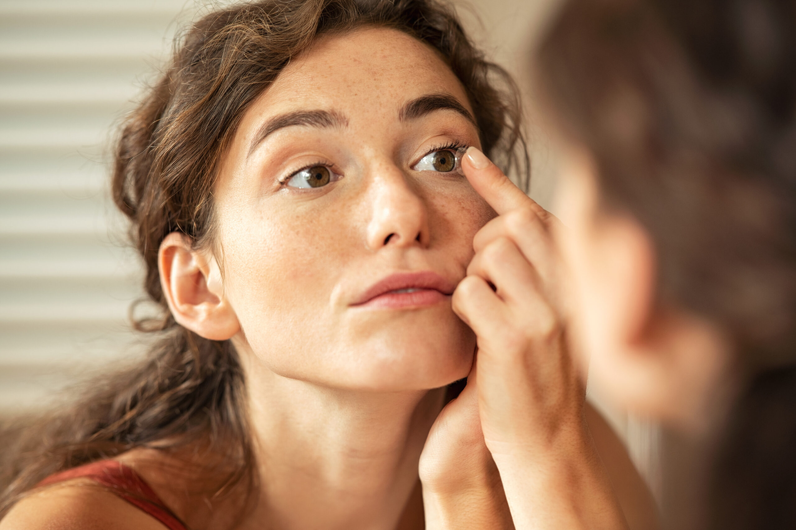 Woman inserting a contact lens